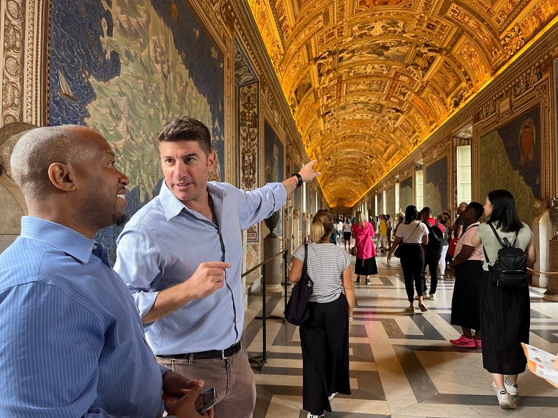 A man leading a group at the Vatican.