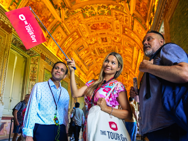 Woman holding The Tour Guy Tote bag while leading a tour.