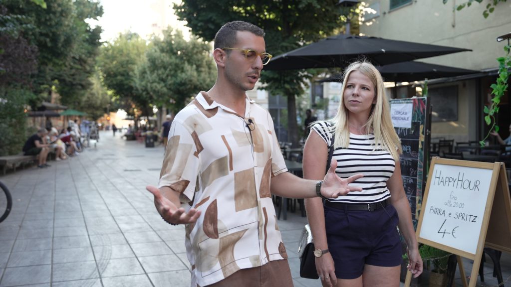 A woman walks with an Italian tour guide. 