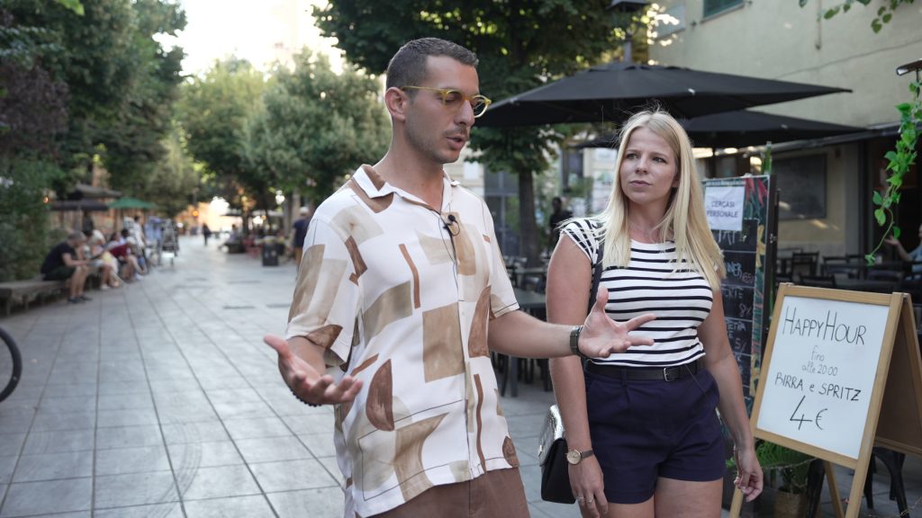 A woman walks with an Italian tour guide.