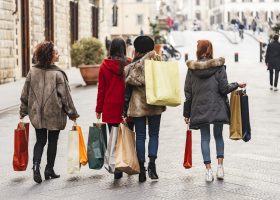 Happy female group of friends doing shopping together