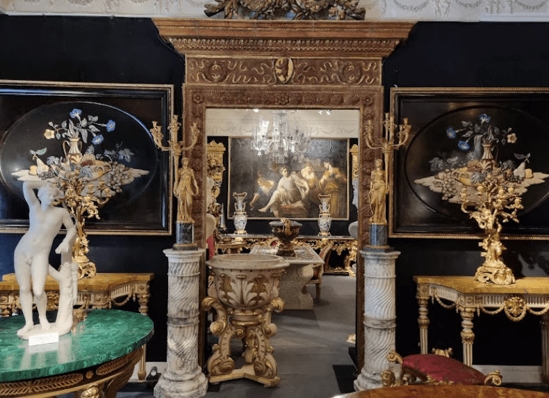 Orante gold sculptures and marble statues in a room.