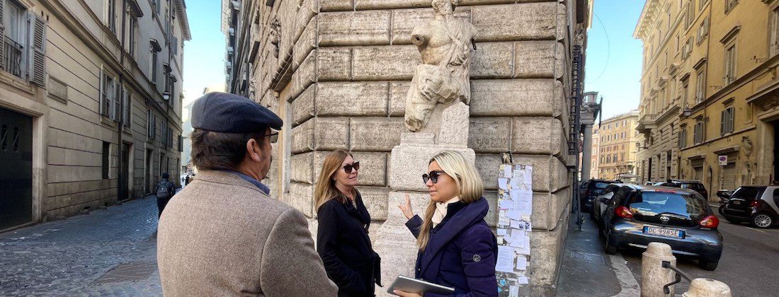 people looking at statue in the street of rome