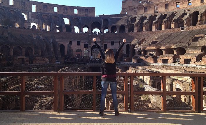woman cheering in an empty arena floor in the colosseum in rome