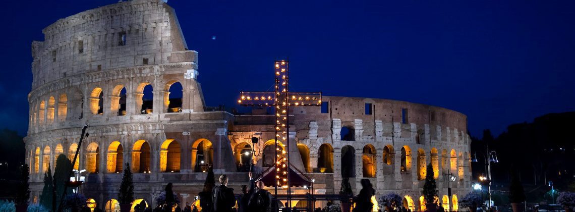 Evening view of the cross in front of the colosseum during the Via Crucis at easter in Rome