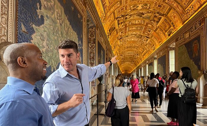 Tour guide showing a visitor the Gallery of Maps in the Vatican Museums