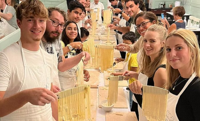people holding pasta noodle in Rome kitchen