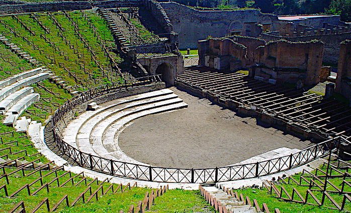 The large main amphitheater in the Pompeii Archaeological  Park, semi-circular in shape with the remains of a stage.