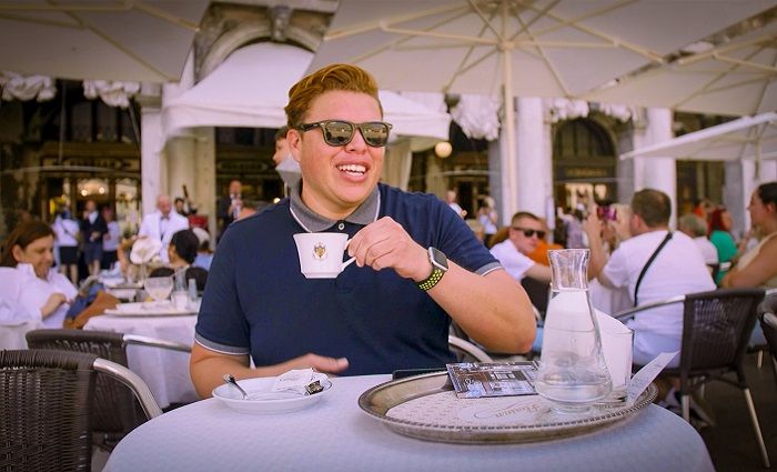 A mna drinking coffee in Caffe Florian in St. Mark's Square near St. Mark's Basilica