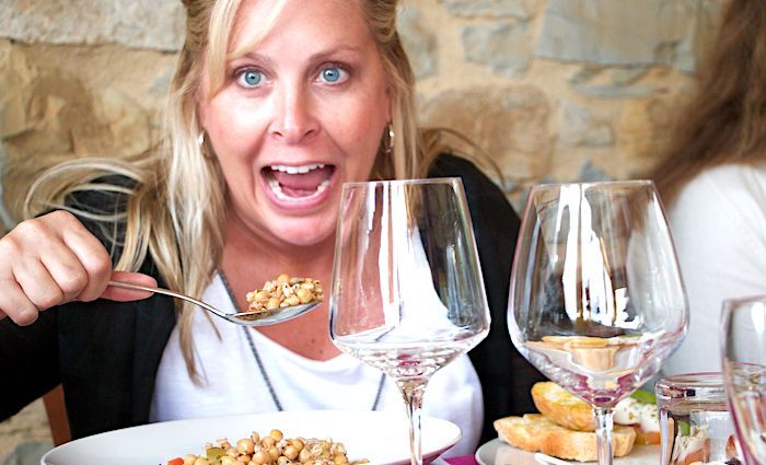 Lady raising a spoonful of food to her mouth.