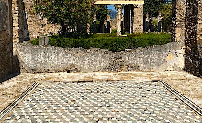 The remains of the wall and floor with mosaics of the House of the Tragic Poet in the Pompeii Archaeological  Park.