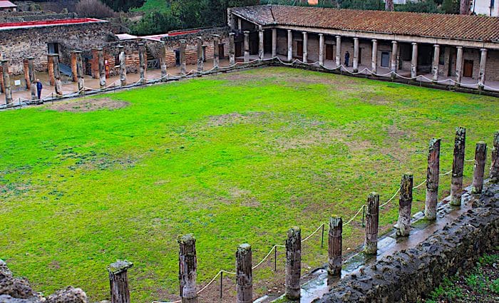 Central field surrounded by the remains of the Gladiator Barracks structure and columns in the Pompeii Archaeological  Park.