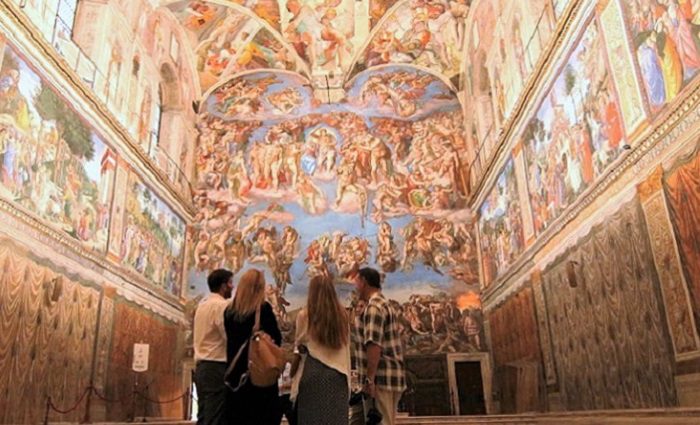 Visitors admiring the interior of the Sistine chapel.